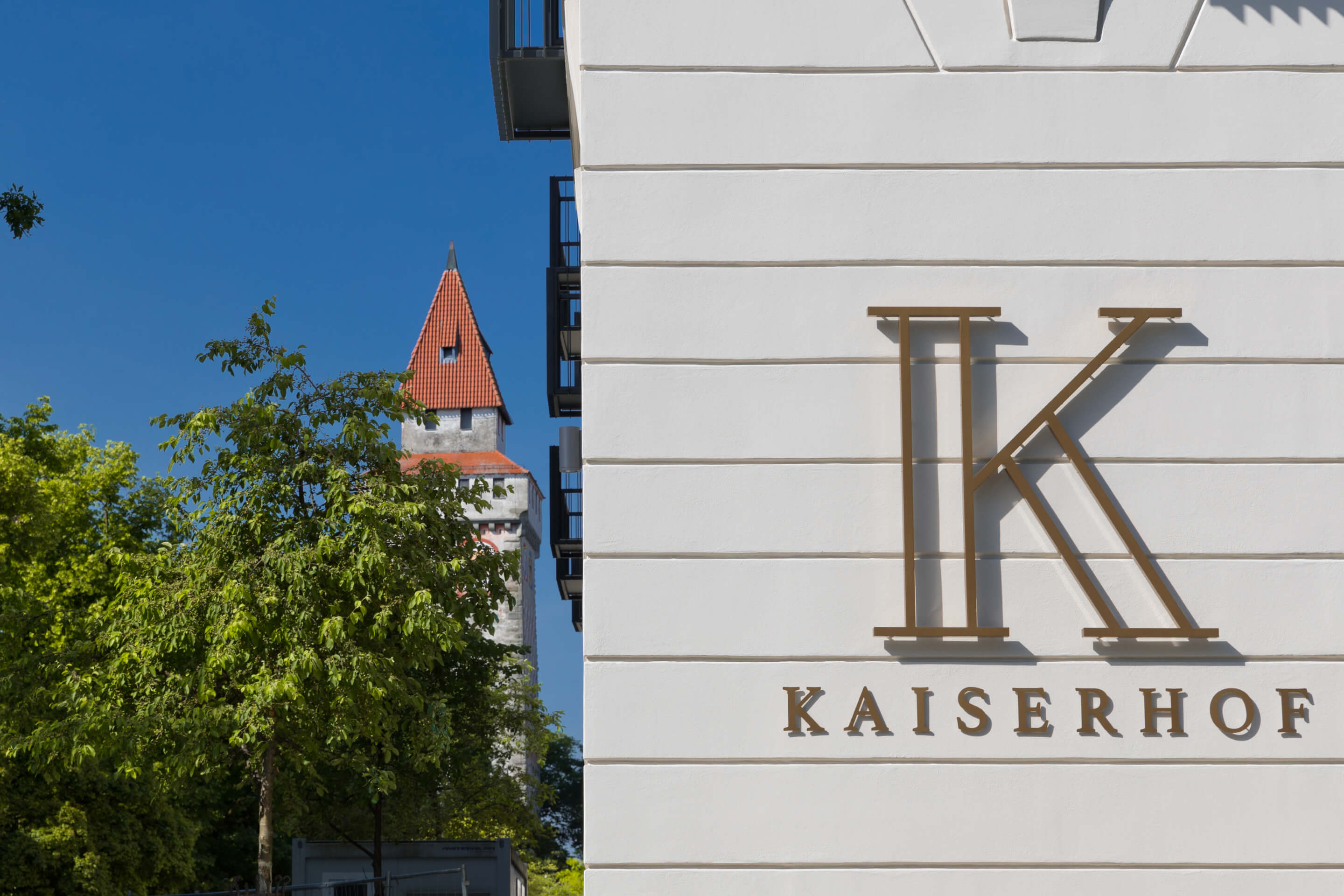 Kaiserhof-Fassade mit Logo und dem gemalten Turm im Hintergrund