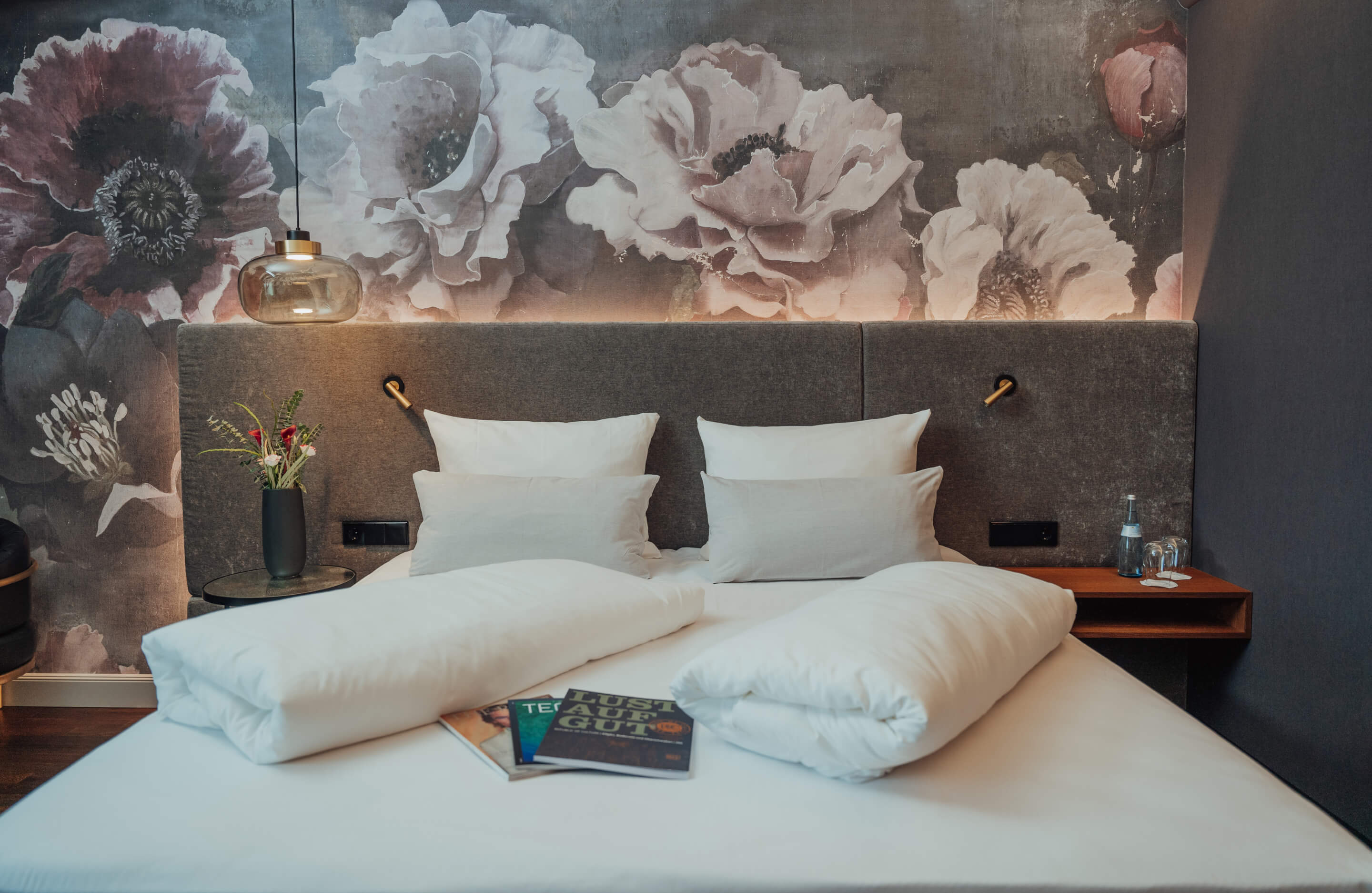 Hotelzimmer mit individuellen Wand-Designs, Boxspringbett und Magazinen