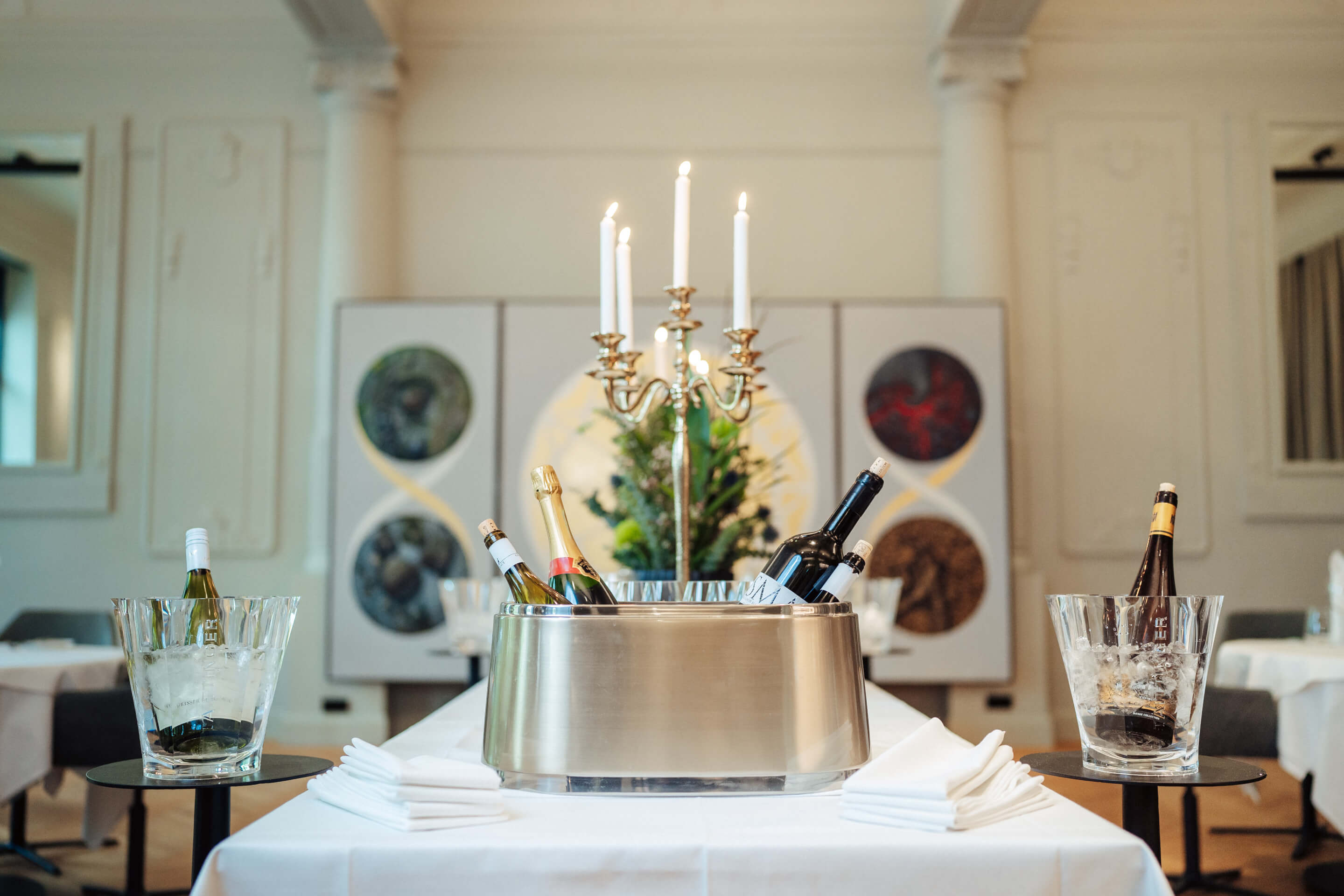 Flaschen Sekt in einem Eiseimer stehen zentral in einem eleganten, gut beleuchteten Raum