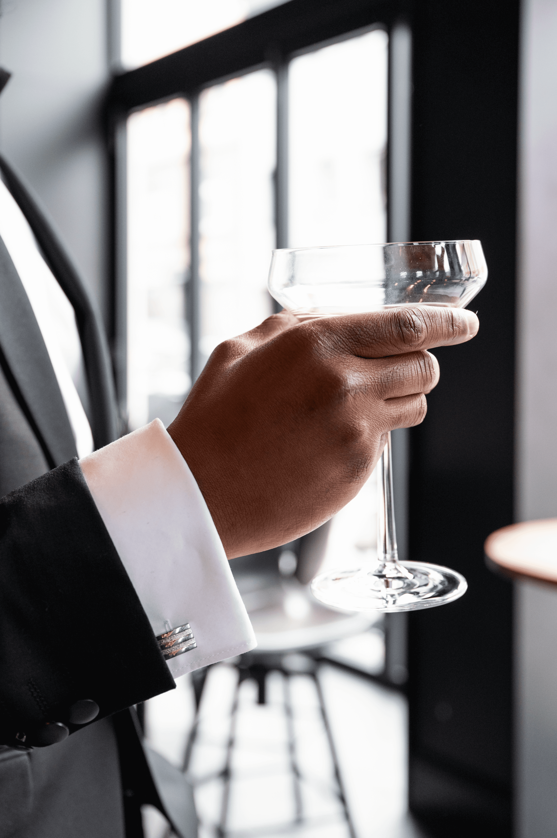 Eine Hand, die ein edles Glas mit einem Getränk hält