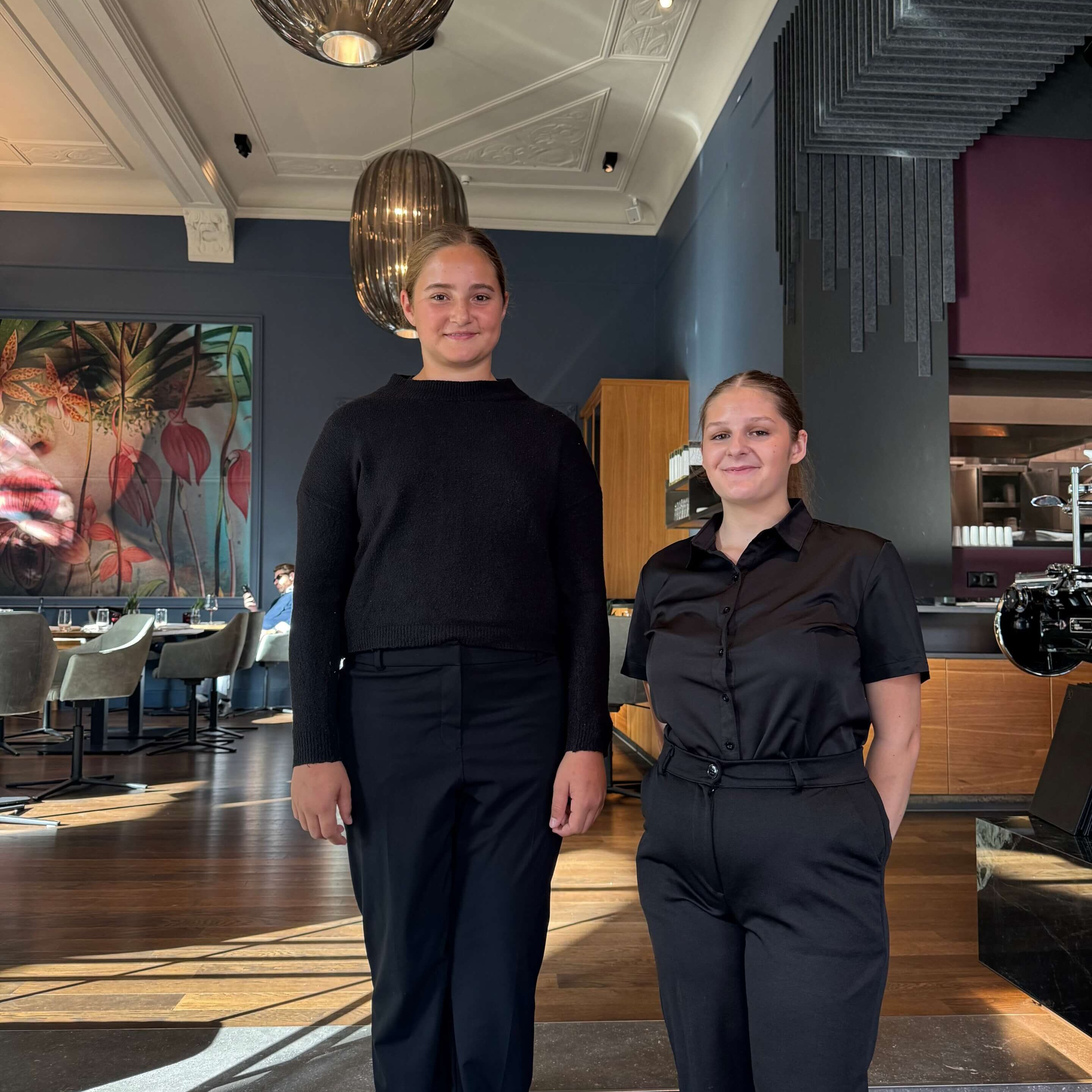 Zwei Auszubildende stehen im modernen Restaurantbereich des Hotel Kaiserhof.